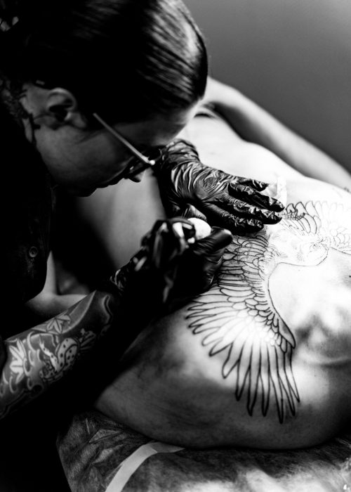 Tattoo salon process. A tattoo girl stuffed a tattoo. the process of stuffing a tattoo on the body. Hands close-up.
